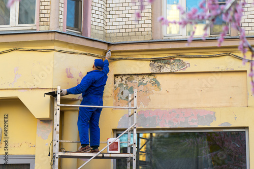 a worker repairing the wall of a building photo