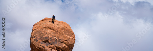 Rock climber on top of a hoodoo, Utah