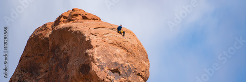 Rock climber on top of a hoodoo, Utah