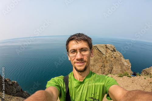 Man makes selfie on the rocks by the sea