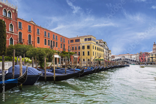 View of the Grand canal, a pier with gondolas and Rialto bridge on the horizon, Venice, Italy © vesta48