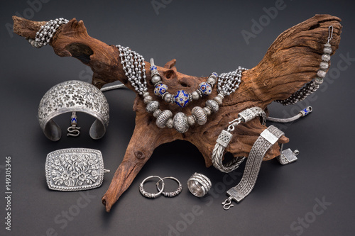 Collection of antique traditional silver jewelry on old wood and black paper