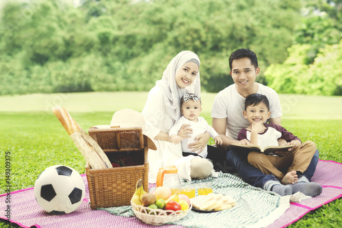 Muslim family with a book in the park