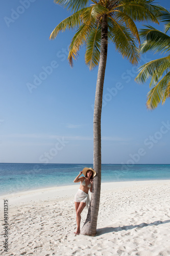 Donna con palma in spiaggia