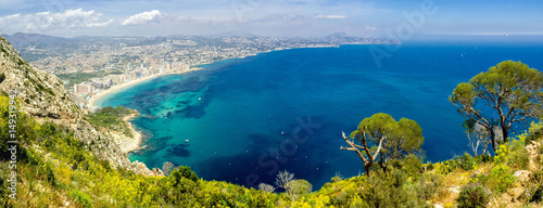 Panoramic landscape of Calpe. Ascension and hiking in the Rock of Ifach. Vacation and sunshine tourism on the beaches of Alicante, Spain. 