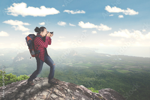 Young male taking a photo on the mountain