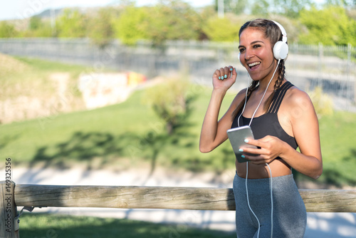 Fototapeta Naklejka Na Ścianę i Meble -  close up portrait of a woman doing sport resting outdoor smiling and listening music .