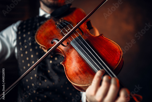 Male violinist playing classical music on violin