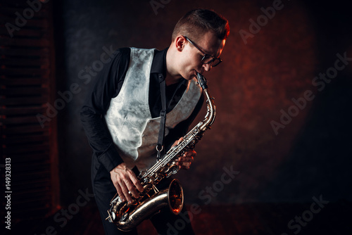 Male saxophonist playing jazz melody on saxophone