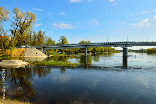 Most nad rzeką, brzegiem i drzewa w Pułtusku.