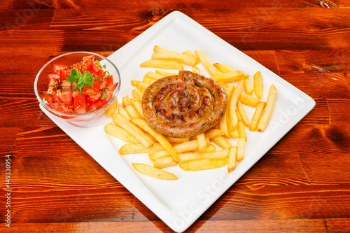 Fire grilled sausage with fries and tomato salad