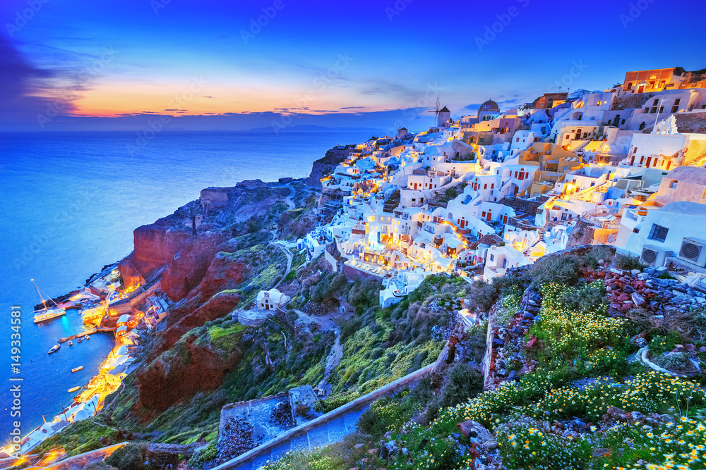 Classical view from sunset point over Oia village white and blue architecture, Santorini island, Greece. Incredible evening scenery. Santorini is popular European travel destination for honey moon.