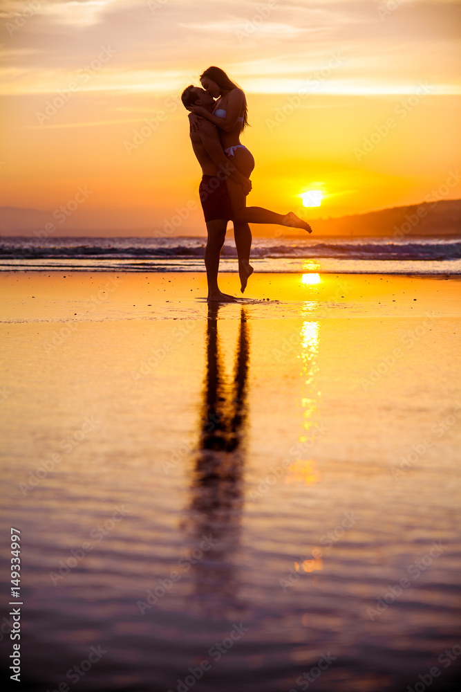 Young couple embracing on the beach at sunset