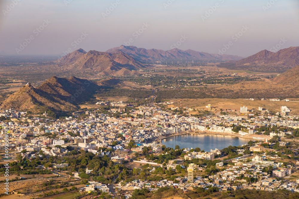 Aerial view of Pushkar, the town with the holy lake and the surrounding hills and rural landscape. Travel destination in Rajasthan, India.