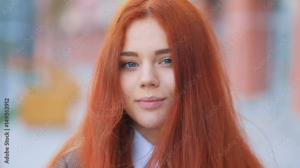 Beatiful young business girl with hair swaying by wind tenderly looking into the camera and smiling, urban landscape Steadicam slow motion video Beatiful young business girl with hair swaying by wind tenderly looking into the camera and smiling, urban landscape Steadicam slow motion video