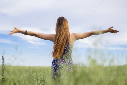 Chica feliz en el campo en primavera con brazos abiertos. 