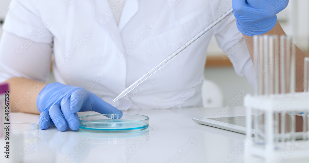Close up of scientific research hands with clear solution in laboratory Close up of scientific research hands with clear solution in laboratory