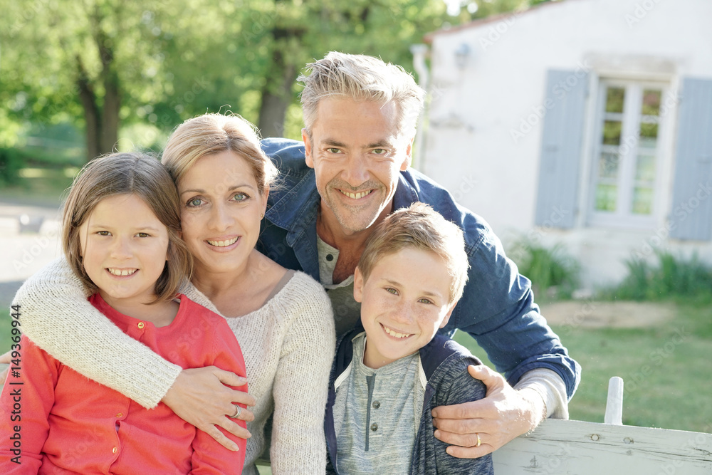 Fototapeta premium Portrait of happy family of four sitting on bench