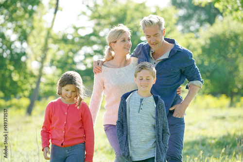 Cheerful family walking in park on sunny day