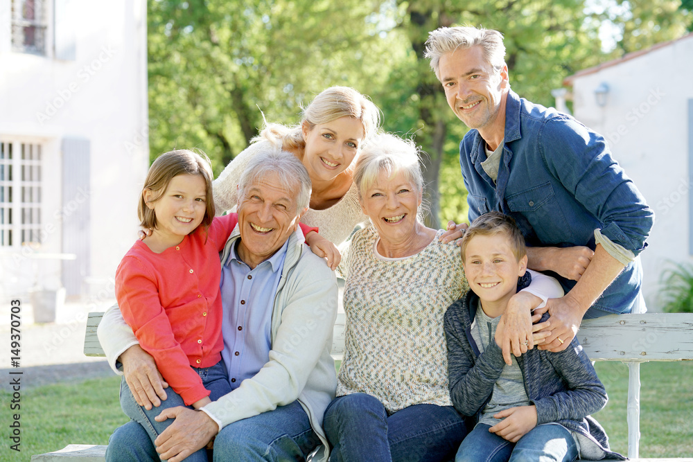 Portrait of intergenerational family sitting on bench