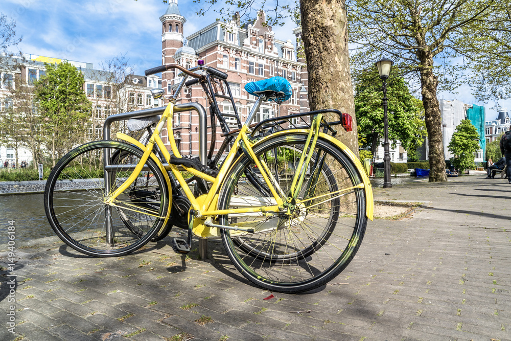 Yellow bike parked in the streets of amterdam