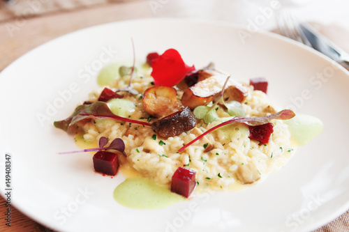 Risotto with fried porcini mushrooms on plate, toned