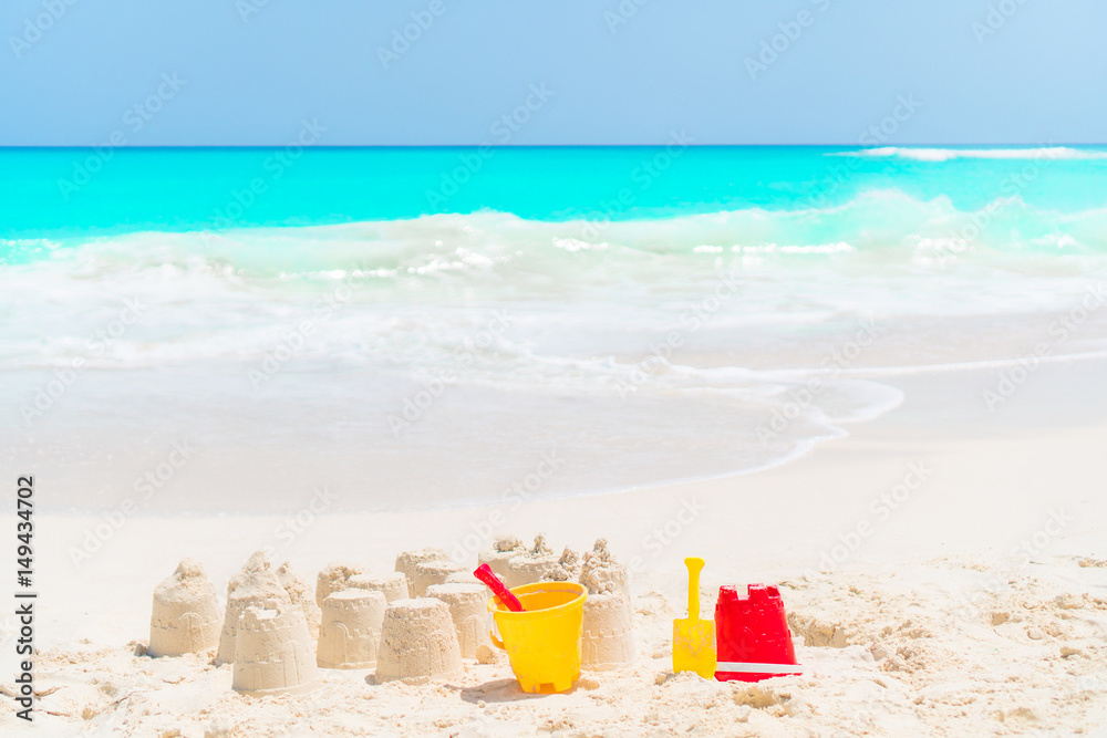 Sandcastle at white beach with plastic kids toys and sea background Sandcastle at white beach with plastic kids toys and sea background