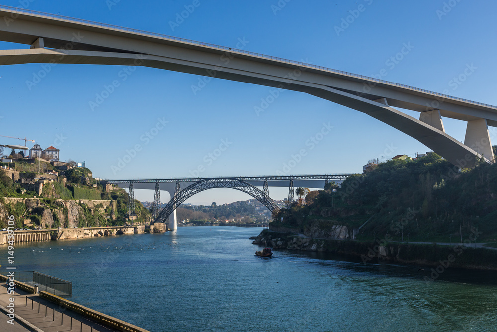 Naklejka premium Prince Henry Bridge between cities of Porto and Vila Nova de Gaia, Portugal. Old and new railway bridges on background