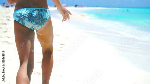Little girl running on the white beach in shallow water. Concept of beach vacation and barefoot. SLOW MOTION