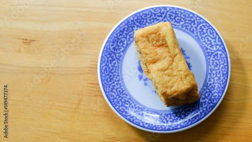 Fried bean curd in blue chinese dish on wooden table