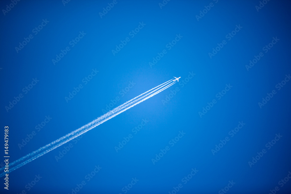 Fototapeta premium White plane flying high in the sky