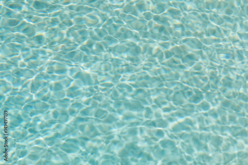 Patterns of water and light reflections in a swimming pool with a green bottom.  