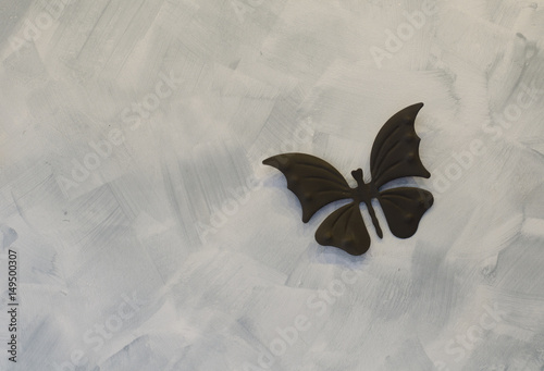 Iron butterfly on cement background photo