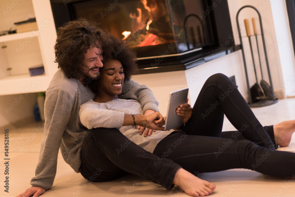 multiethnic couple using tablet computer on the floor