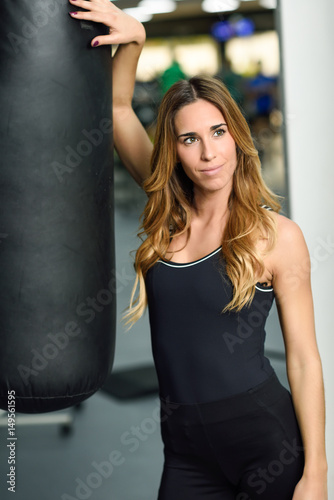 Female personal trainer with punching bag in a gym © javiindy