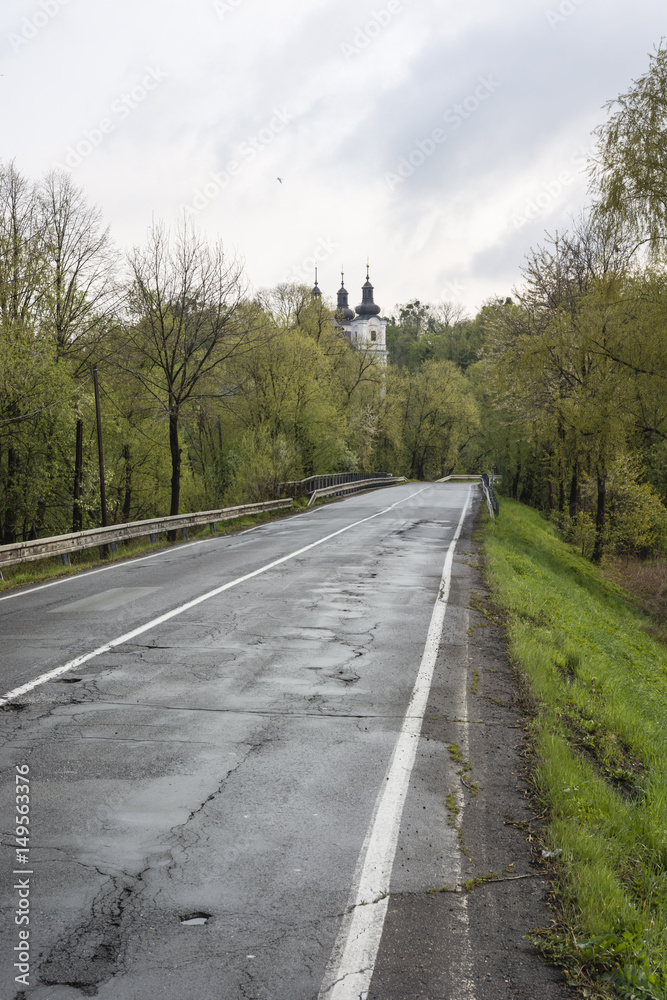 Fototapeta premium Asphalt road with a church in the background.