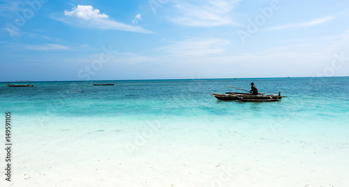 landscape with man in a boat in ocean near African shore