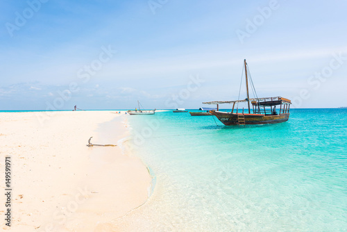 anchored boat on african seashore with blue sky on the background