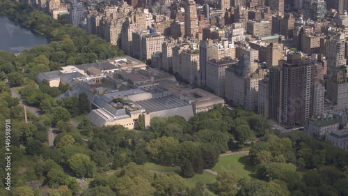 AERIAL: Flying above Upper East side overlooking lush green Central Park along the 5th Avenue in sunny New York City. Luxury condominium apartment buildings with Central Park view and MET museum