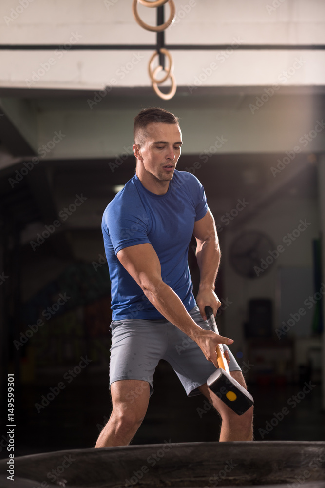 Fototapeta premium man workout with hammer and tractor tire