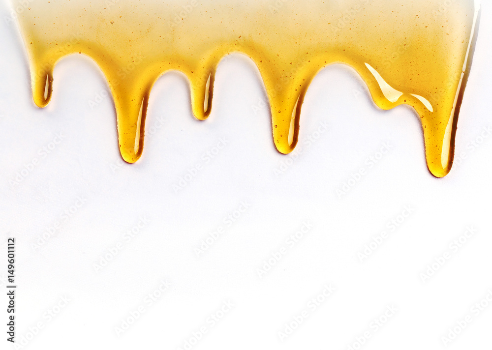 Dripping honey seamlessly repeatable from the top over white with copyspace and text Dripping honey seamlessly repeatable from the top over white with copyspace and text
