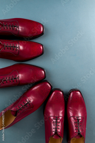 Red oxford shoes on blue background. Three pair  brogues. Top view.