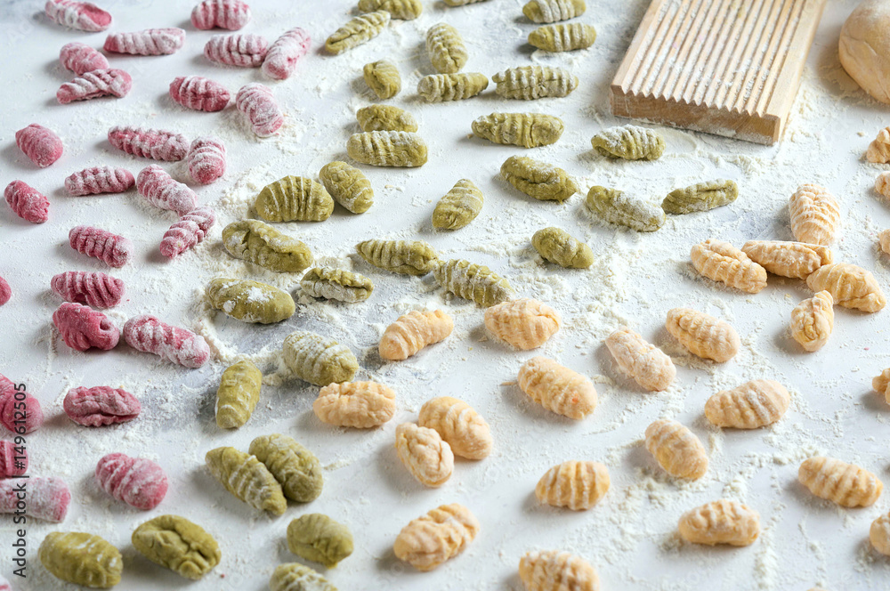 Homemade raw gnocchi with spinach, carrots and beets on the table with the Board