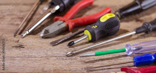 Screwdrivers and other tools on a wooden surface