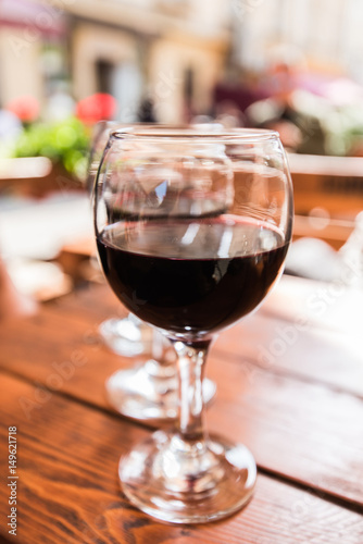 Three glasses of red wine on the vibrant restaurant background. Selective focus.