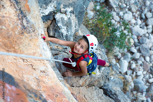 Little Girl doing Rock Climbing Training on vertical Wall
