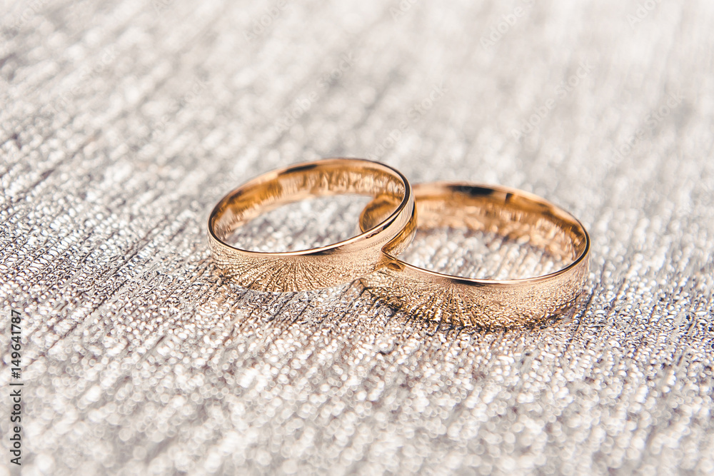Golden rings on silver plate background. Golden rings on silver plate background.