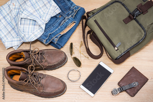 Men's casual outfits and vacation items for traveler on wood background