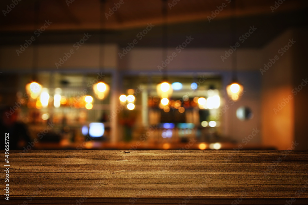 wooden table in front of abstract blurred restaurant lights