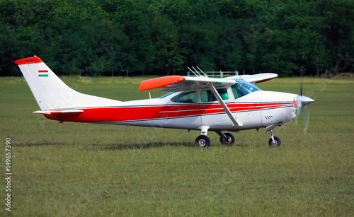 Light red white school airplane on airport grass before take off photo